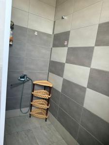 a bathroom with a shower with aige and gray tiles at SunLake House in Balykchy
