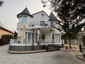 a large white house with a staircase in front of it at Villa Rose Garden in Nyíregyháza