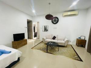a living room with a couch and a tv at Ferringhi Beach Guesthouse-3bed in Batu Ferringhi
