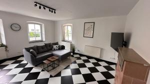 a living room with a couch and a checkered floor at Ferienwohnungen Luitpold - Boutique Apartments in Dinkelsbühl