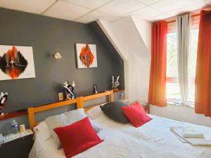 a bedroom with a bed with red and white pillows at Abbaye de Belval in Troisvaux
