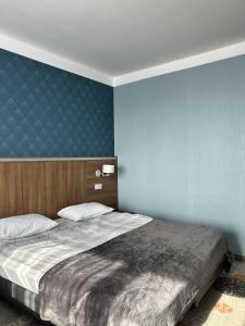 a bedroom with a large bed with a blue wall at Hotel Europa in Lubin +33 photos