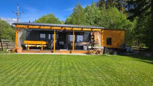 a small shed with a bench in a yard at Tiny House mit Fernblick in Verditz