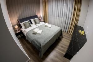 a bedroom with a large bed with two pillows at Apart Hotel Nordic Residence 16H in Suceava