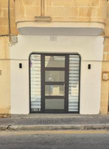 a glass door on the side of a building at Seaside Loft in Marsalforn