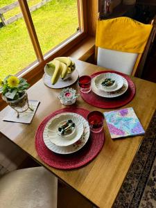 a wooden table with plates of food on it at Goldingen Stone Retreat - Hot Tub and Nature in Kuldīga