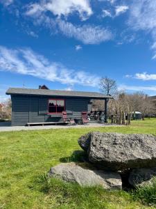 a house with a large rock in front of it at Goldingen Stone Retreat - Hot Tub and Nature in Kuldīga