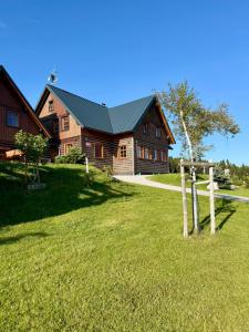 a large wooden house with a green roof at Hotel Vydrovy boudy, Pec pod Sněžkou in Pec pod Sněžkou