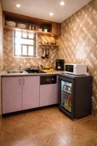 a kitchen with a microwave and a refrigerator at Lake Court Residence in Abuja +13 photos