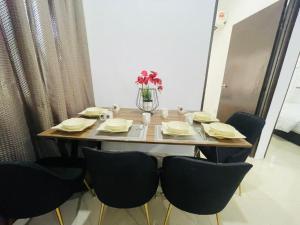 a table with chairs and a vase of flowers on it at Ferringhi Beach Guesthouse-3bed in Batu Ferringhi