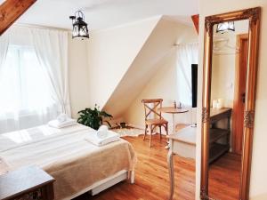 a bedroom with a bed and a table and a chair at Penzion V peřině in Trojanovice
