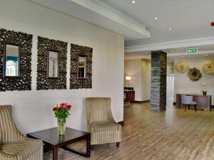 a lobby of a hotel with a table and chairs at ANEW Hotel Capital Pretoria in Pretoria