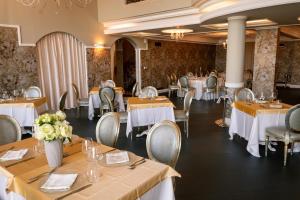 a dining room with tables and chairs with white tablecloths at Essence Sicily - Marina Holiday Hotel & Spa in Balestrate