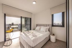 a bedroom with a large bed and a balcony at Lake View Suites in Paralimni