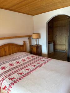 a bedroom with a bed with a red and white bedspread at Petite chambre à la montagne in Ollon
