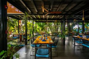 a restaurant with tables and chairs and plants at Yuli Hotel in Uvita