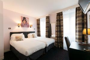 a hotel room with a large bed with white sheets at Prince Monceau in Paris +52 photos