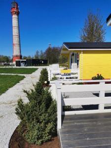 a white fence in front of a lighthouse at Pakri lighthouse camping in Paldiski