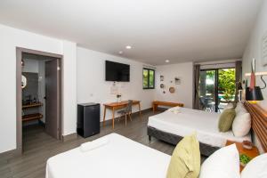 a hotel room with two beds and a living room at Yuli Hotel in Uvita
