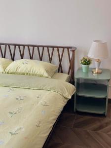 a bed with a nightstand with a lamp and a bed sidx sidx sidx sidx at 1BR Olive & Rouge House in Long Bình +6 photos
