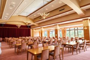 a large banquet hall with tables and chairs at ホテル秘境の湯 in Miyoshi