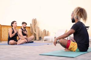three men sitting on the floor in a yoga class at Sunset Surfhouse Morocco in Tamraght Ouzdar