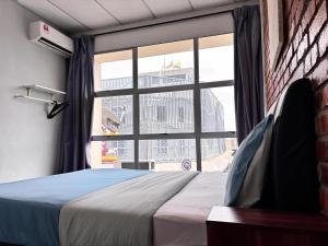 a bedroom with a bed and a large window at Above A Shoplot No Noise Worries 12Pax & FreeWiFi in Ipoh