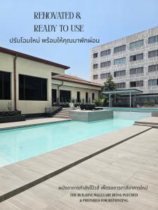 a swimming pool in front of a building at Songphanburi Hotel in Suphan Buri