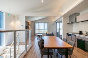 a kitchen and dining room with a wooden table and chairs at YUTORELA 富津 with SAUNA プライベートサウナ完備 in Futtsu