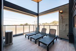 a room with two chairs and a table on a balcony at YUTORELA 富津 with SAUNA プライベートサウナ完備 in Futtsu +30 photos
