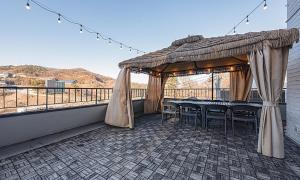 a gazebo on a balcony with a table and chairs at Chuncheon Bali 376 in Chuncheon