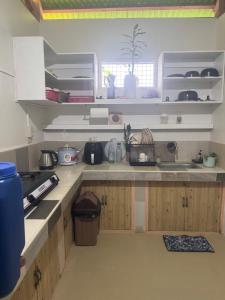 a kitchen with white counters and wooden cabinets at Gabs Haven Transient House in El Nido