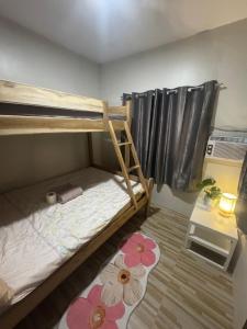 a bedroom with two bunk beds with flowers on the floor at Gabs Haven Transient House in El Nido