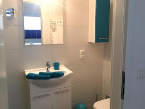 ein Bad mit einem Waschbecken und einem Spiegel in der Unterkunft Apartment Warnemünde 15 in Warnemünde