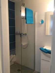 ein Bad mit einer Dusche und einem blauen Handtuch in der Unterkunft Apartment Warnemünde 15 in Warnemünde