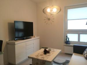 a living room with a flat screen tv on a dresser at Apartment Warnemünde 15 in Warnemünde