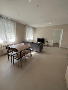 a living room with a table and chairs and a couch at Le Cosy in Saint-Marcellin