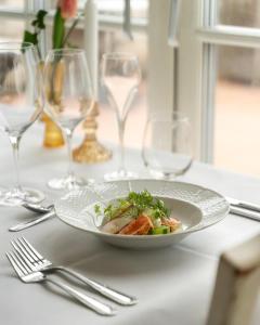 a plate of food on a table with wine glasses at Villa Brunnby in Mölle