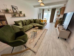 a living room with a green couch and chairs at DaVinci Apartments VRT in Cristian