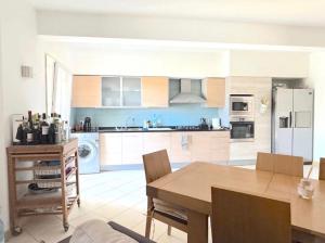 a kitchen with a wooden table and a dining room at Vozinha Residence in Prainha
