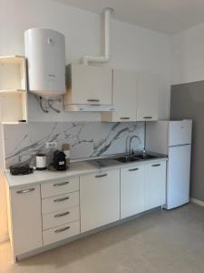 a kitchen with white cabinets and a sink and a counter at Duca d Aosta apartment 4 in Monfalcone