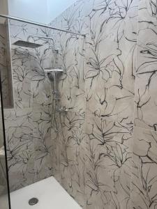a bathroom with a shower with a black and white wallpaper at Duca d Aosta apartment 4 in Monfalcone