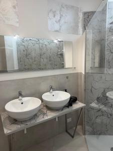 a bathroom with two white sinks and a shower at Duca d Aosta apartment 4 in Monfalcone +2 photos