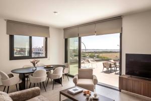 a living room with a television and a table and chairs at Lake View Suites in Paralimni