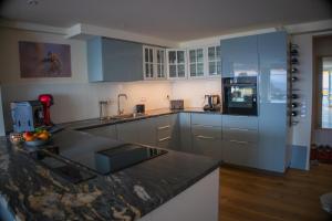 a kitchen with blue cabinets and a counter top at Ihre exklusive Auszeit im Allgäu in Scheidegg +3 photos