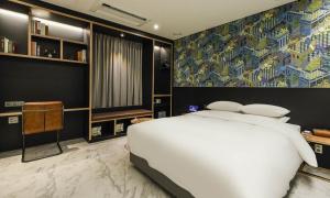 a bedroom with a large white bed and a colorful wall at Incheon Guwol Hotel Bay 204 in Incheon