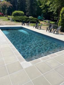 a swimming pool with benches in a park at Cabane Magique 4 Personnes in La Bâtie-Montgascon
