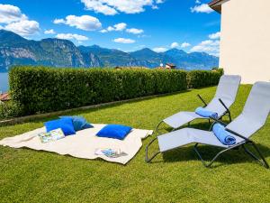two chairs and a blanket and a table and chairs on the grass at Azzurra Beths House in Brenzone sul Garda