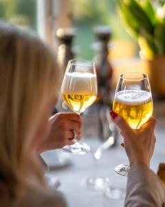 a woman holding up two glasses of wine at Villa Brunnby in Mölle +169 photos