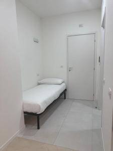 a white room with a bed and a glass door at Duca d Aosta apartment 3 in Monfalcone +1 photo